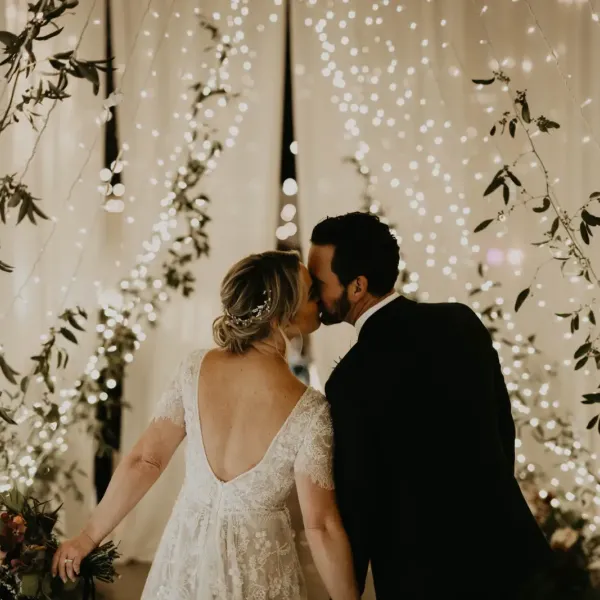 Wedding couple kissing under lights