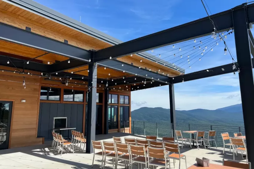 Outdoor seating overlooking mountains with lights overhead