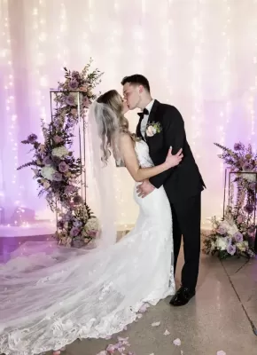 Bride and Groom kiss in front of light curtain