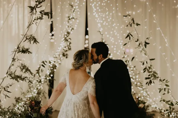 Wedding couple kissing under lights